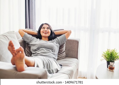 Pretty young asian woman relaxing on a sofa alone