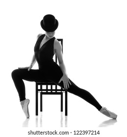 pretty young ballerina sitting on the chair. Isolated on white