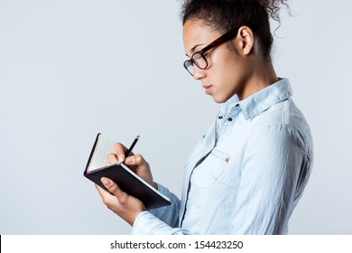 Pretty Young Black Woman Taking Notes At Home