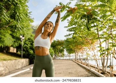 pretty young blond smiling woman doing sport exercises in morning park, skinny fit dressed in sports wear outfit leggings and top, summer health motivation, strong body, stretching - Powered by Shutterstock