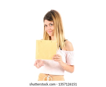 Pretty Young Blonde Teenager Girl Holding An Envelope Against A White Background