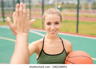 Pretty young blonde woman in activewear giving high-five to her friend - Powered by Shutterstock