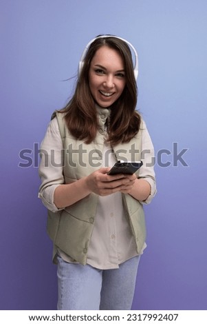 pretty young brunette woman listening to music using headphones and mobile phone