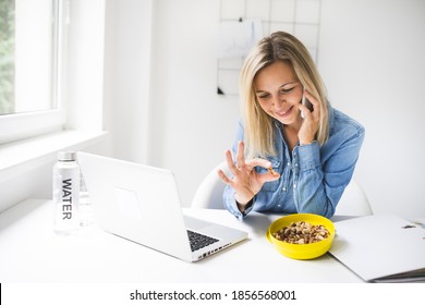 Pretty Young Business Woman Eating Nuts In Office