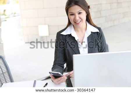 A pretty and young business woman with laptop computer at work