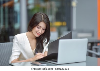 Pretty young business woman sitting on workplace, woman using laptop while sitting at her desk, businesswoman sitting in the office and working on laptop, woman using laptop, Selective focus. - Powered by Shutterstock