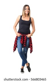 Pretty Young Casual Woman With Shirt Tied Around Waist And Hands In Pockets Smiling. Full Body Length Portrait Isolated Over White Studio Background.