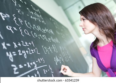 Pretty Young College Student Writing On The Chalkboard/blackboard During A Math Class (color Toned Image; Shallow DOF)