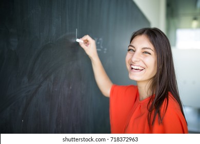 Pretty, Young College Student Writing On The Chalkboard/blackboard During A Math Class