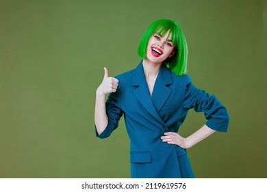 Jolie jeune femme, belle apparence, veste verte perruque bleue posant un arrière-plan couleur non altéré