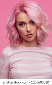 Pretty Young Female With Hair Of Unusual Color Looking At Camera While Standing On Pink Background