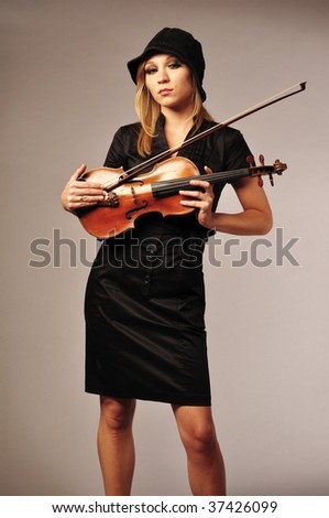 Pretty young female violinist over gray background