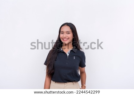 A pretty young Filipino woman in a black polo shirt and khaki pants. Isolated on a white background.