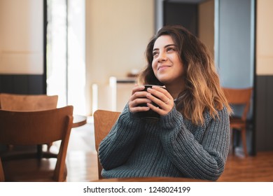 Pretty young girl drinking coffe, tea in cafe - Shutterstock ID 1248024199