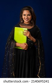 Pretty young girl posing with book on blue background