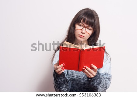 Pretty young girl with red book in glasses isolated