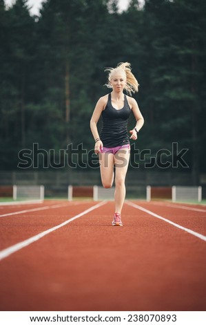 A pretty young girl running and stretching on the runway