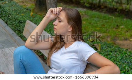 Pretty young girl seating relaxing and thinking in square