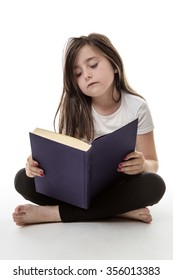 Pretty Young Girl Is Sitting Cross Legged Whilst Reading Her Book Isolated On White 