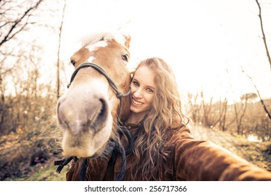 Pretty young girl taking a funny selfie with a hilarious horse - Powered by Shutterstock