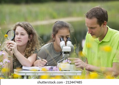 Pretty young girls having outdoor science lesson  exploring nature 