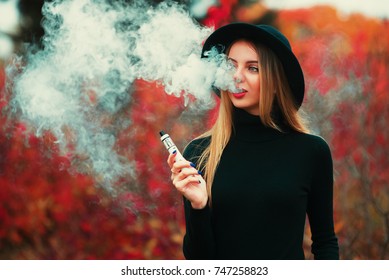 Pretty Young Hipster Woman In Black Hat Vape Ecig, Vaping Device.