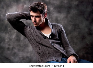 Pretty young man posing on dark background