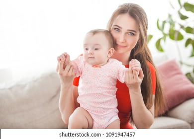 Pretty young mother holding her baby girl 