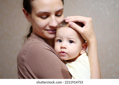 Pretty Young Mother Holding Her Newborn Baby Boy. Close Up.