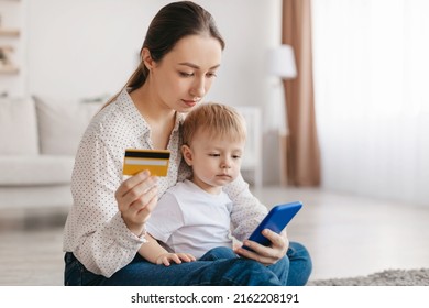 Pretty Young Mother And Little Kid Son Buying Something On Internet, Using Cellphone And Holding Credit Card, Mom And Child Shopping Online Together, Copy Space