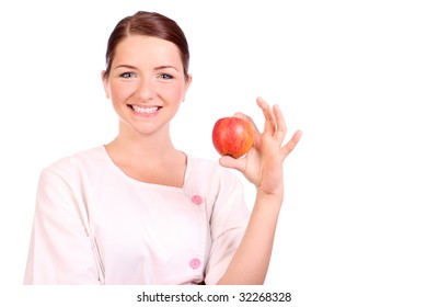 A Pretty Young Nurse/dietician Holding Up An Apple And Smiling.