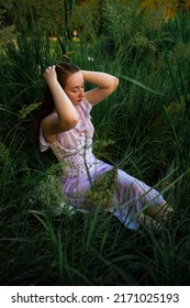 pretty young red head woman outdoor in the grass in summertime