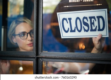 Pretty Young Shop Owner Turning Closed Sign