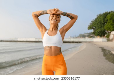 pretty young smiling woman doing sports in the morning by the sea beach in stylish sport outfit sportswear skinny strong body healthy fit lifestyle happy enjoying having fun - Powered by Shutterstock