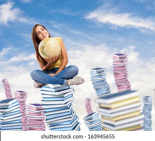 Pretty Young Student Holding A Earth Globe Sitting On A Big Books Pile