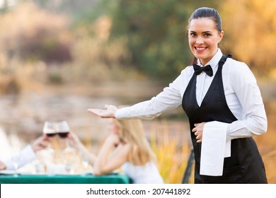 pretty young waitress welcomes customers to romantic dinning environment - Powered by Shutterstock