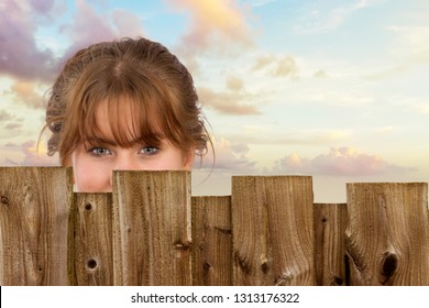 pretty young woman behind a wooden fence