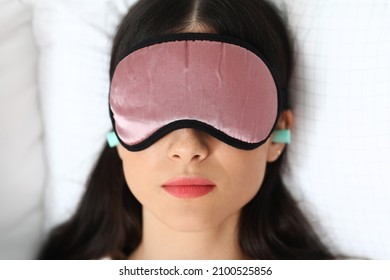 Pretty Young Woman With Blue Ear Plugs And Sleeping Mask On Bed, Closeup