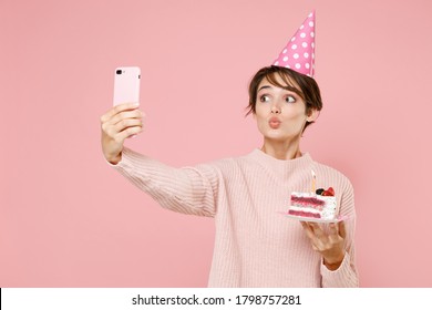 Pretty Young Woman In Casual Sweater Birthday Hat Isolated On Pastel Pink Wall Background. Birthday Holiday Party People Emotions Concept. Celebrating Hold Cake Doing Selfie Shot On Mobile Phone