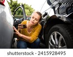 Pretty, young woman checking the state of a car for insurance purposes, prior to start driving it after renting it from a car rental. Automotive damage liability concept.