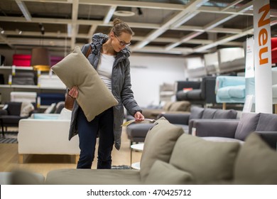 Pretty, young woman choosing the right furniture for her apartment in a modern home furnishings store (color toned image; shallow DOF) - Shutterstock ID 470425712