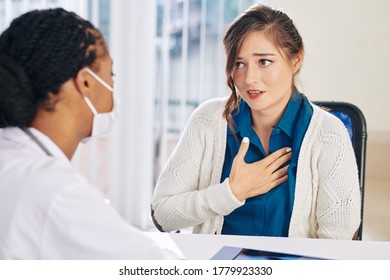 Pretty Young Woman Complaining About Chest Pain When Visiting Doctor