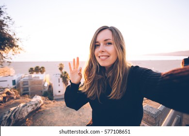 Pretty young woman doing selfie near the ocean. Concept of happiness and inspiration of travel. 