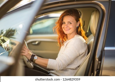 Pretty, young woman  driving a car -Invitation to travel. Car rental or vacation. - Shutterstock ID 1264829359