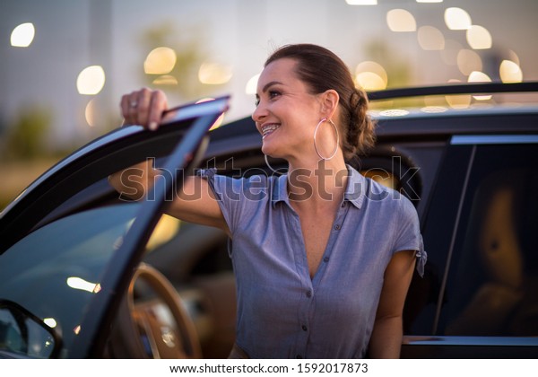 Pretty, young woman  driving a car\
-Invitation to travel. Car rental,  car ownership or\
vacation