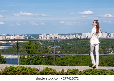 Pretty Young Woman Enjoying City View From Balcony