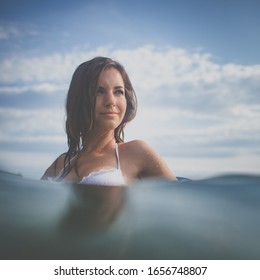 Pretty, young woman enjoying a day at the beach, relaxing on inflatable mattress - Powered by Shutterstock