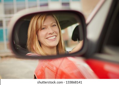 Pretty Young Woman Face In Car Mirror