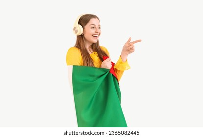 Pretty young woman with flag of Italy listening to music and pointing at something on white background - Shutterstock ID 2365082445