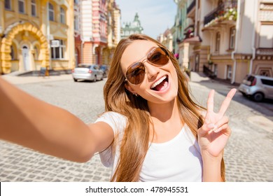 Pretty Young Woman In Glasses Making Selfie And Shwing Two Fingers